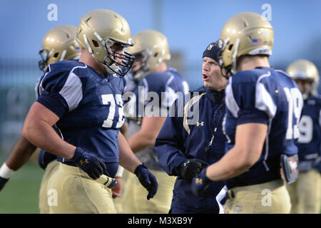 141203-D-FW 736-018 - Ashley Ingram, Naval Academy Offensive Line Coach, gibt Anweisungen zu Sophomore offensive Guard, Adam West, ein Mitglied der Navy midshipmen Football Team, wie das Team für die 115 jährlichen Army/Navy football Spiel vorbereitet. Die Midshipmen von der United States Naval Academy in Annapolis, Maryland, für ihre bevorstehenden Bratrost Schlacht gegen die Kadetten der United States Military Academy in West Point, New York vorbereiten, an die Naval Academy Praxis-Service während eines kühlen, nassen Dezember Abend. Die 115. jährliche Army/Navy spiel Lochfraß die Schwarzen Ritter von Armee gegen Stockfoto