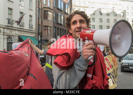 Petross Elia der Vereinigten Stimmen der Welt spricht an der Sammlung auf der Straße vor dem hinteren Eingang von Sotheby's verlangen die Wiedereinsetzung von 2 Arbeiter für protestieren für die Lohnfortzahlung im Krankheitsfall, Urlaubsgeld und Renten. Stockfoto