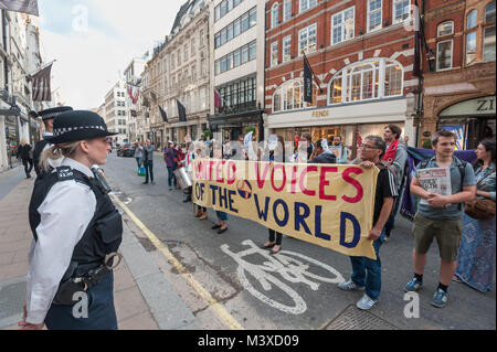 Polizei stehen und zusehen, wie United Stimmen der Welt Protest außerhalb Sotheby's für die wiedereinsetzung von 2 Arbeiter entlassen, weil sie für die Lohnfortzahlung im Krankheitsfall, Urlaubsgeld und Renten. Stockfoto