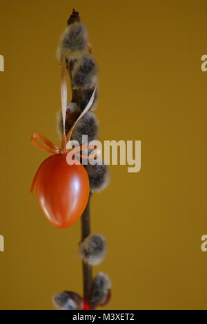 Orange Ostern Osterei auf einem Palm-Kitten mit orangen Hintergrund Stockfoto