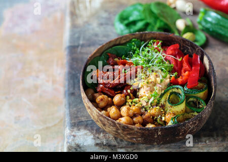 Vegan Buddha Schüssel mit Kichererbsen, getrocknete Tomaten, Zucchini und Sprossen Stockfoto