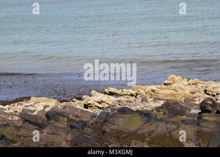 Peel Bay, Schälen, Insel Man. Sauberes Wasser. Auf den Felsen und im Meer am Ende der Promenade Algen Stockfoto