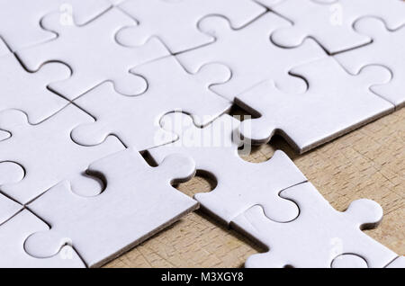 Weiß Stichsäge/Puzzle mit einer Zeile in falscher Position, über holztisch Hintergrund, Symbol der Problemlösung und neue Vision Stockfoto