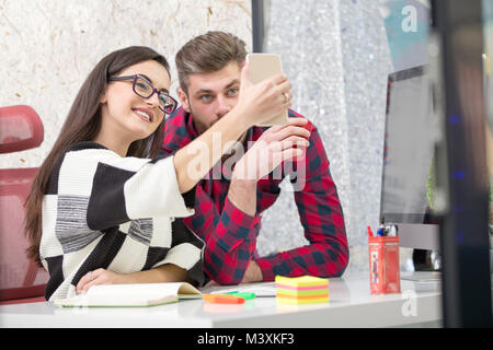 Business Leute, die Fotos auf mobile oder Smart Phone und glücklich lächelnd. Arbeitnehmer in den Pausen. Geschäftskonzept. Stockfoto