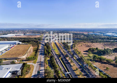 Riesige automotive Autobahnkreuz zwischen High-speed mehrspurigen Schnellstraßen in Sydney West zwischen M4 und M7 unter strahlend blauem Himmel, umgeben von Indus Stockfoto
