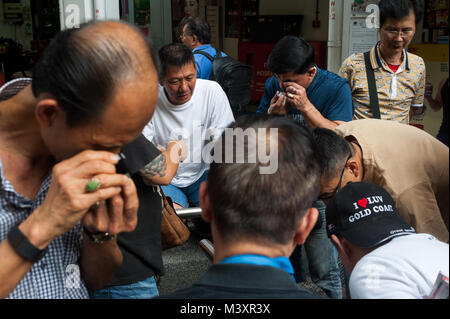 10.02.2018, Singapur, Republik Singapur, Asien - Käufer und Verkäufer wenig Charme und Amulette mit Buddha Figuren auf einem Flohmarkt zu prüfen. Stockfoto