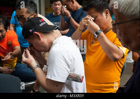 10.02.2018, Singapur, Republik Singapur, Asien - Käufer und Verkäufer wenig Charme und Amulette mit Buddha Figuren auf einem Flohmarkt zu prüfen. Stockfoto