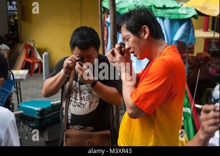 10.02.2018, Singapur, Republik Singapur, Asien - Käufer und Verkäufer wenig Charme und Amulette mit Buddha Figuren auf einem Flohmarkt zu prüfen. Stockfoto