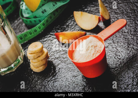 Protein Pulver in Schaufel und Früchte auf steinernen Tisch Stockfoto