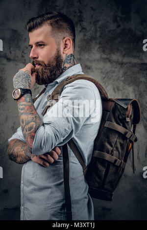 Ein Mann mit Tattoos auf seine Arme und Hals mit Rucksack auf seinem Bac Stockfoto