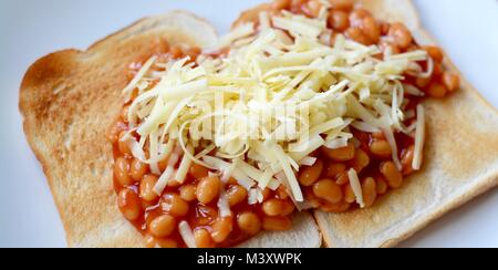 Gebackene Bohnen auf Toast überbacken mit Geriebener Cheddar-Käse Stockfoto