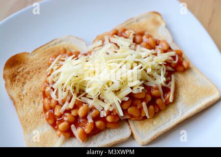 Gebackene Bohnen auf Toast überbacken mit Geriebener Cheddar-Käse Stockfoto