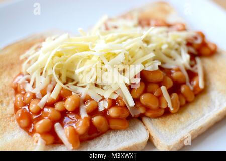 Gebackene Bohnen auf Toast überbacken mit Geriebener Cheddar-Käse Stockfoto