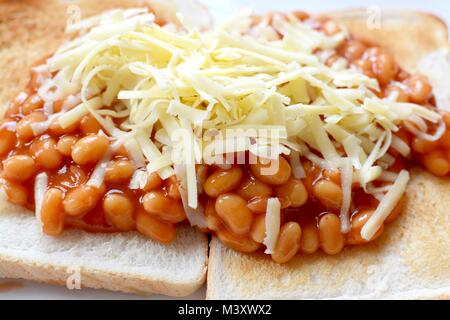 Gebackene Bohnen auf Toast überbacken mit Geriebener Cheddar-Käse Stockfoto