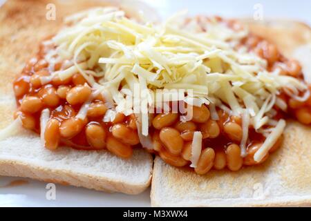 Gebackene Bohnen auf Toast überbacken mit Geriebener Cheddar-Käse Stockfoto