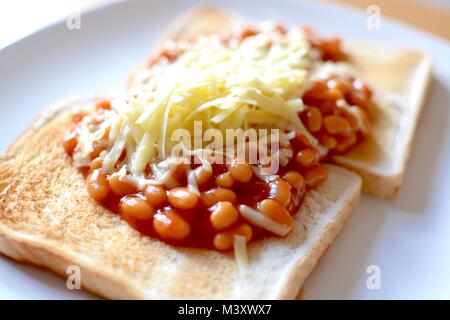 Gebackene Bohnen auf Toast überbacken mit Geriebener Cheddar-Käse Stockfoto