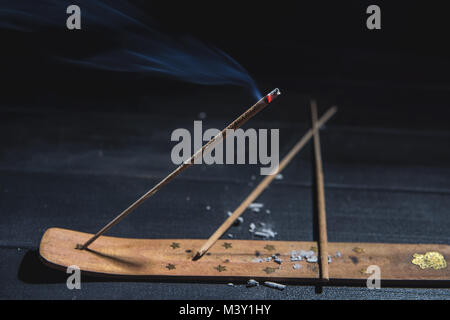 Schwelende aromatische Stick in der Dunkelheit, eine Menge Rauch Stockfoto