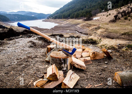 Ax gehaftet in einem Buche Stich mit Holzblöcken als Hintergrund. Auf dem Berg Stockfoto