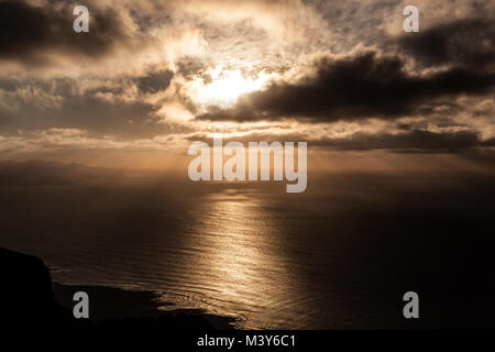 Batería del Rí-o, Lanzarote/Spanien: Blick auf einen atemberaubenden Sonnenuntergang am Meer von der Plattform des Mirador del Río an einem bewölkten Tag Stockfoto