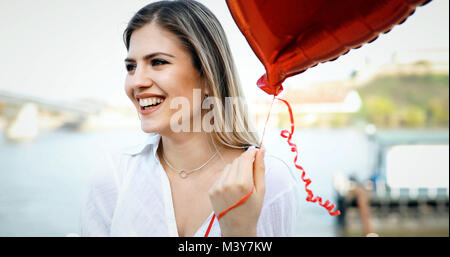 Girl posiert im Freien im Sommer mit bunten Luftballons Stockfoto