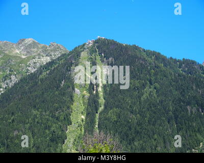 Panoramablick auf die Landschaft von grünen Wald und Seilbahn auf alpinen Berge in Französische Alpen von Chamonix Mont Blanc Dorf in Frankreich gesehen, klare blaue Stockfoto