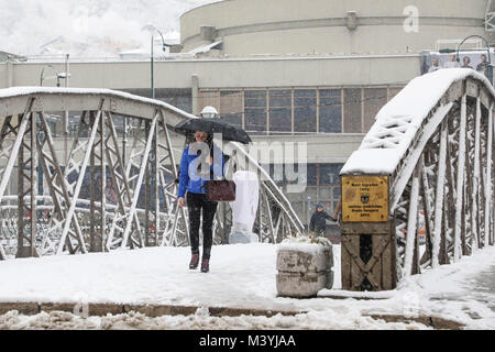 Sarajevo, Bosnien und Herzegowina. 13 Feb, 2018. Eine Frau geht über snow-covered Bridge in Sarajewo, Bosnien und Herzegowina, am 13.02.2018. Schneefall schlagen Sarajevo hier am Dienstag. Credit: Haris Memija/Xinhua/Alamy leben Nachrichten Stockfoto