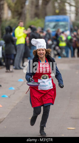 Victoria Tower Gardens, London, UK. 13. Februar, 2018. Media Team Rennen der Parlamentarischen Team an der 21. jährlichen Rehab parlamentarischen Pfannkuchen Rennen am Faschingsdienstag. Jo Coburn von BBC Tagespolitik racing der Zielgeraden. Credit: Malcolm Park/Alamy Leben Nachrichten. Stockfoto