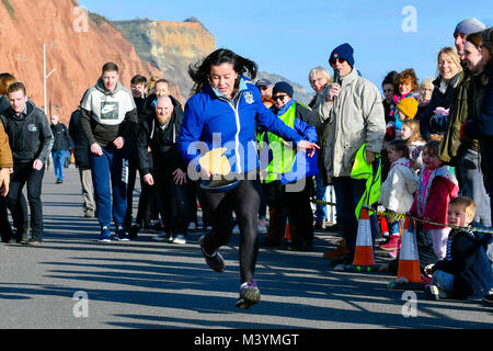 Honiton, Devon, Großbritannien. 13. Februar 2018. Sid Valley Rotary Club Pfannkuchen Racing an der Küste von Sidmouth in Devon. Foto: Graham Jagd-/Alamy Leben Nachrichten. Stockfoto