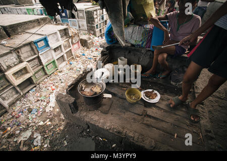 April 7, 2015 - Manila, Manila, Philippinen - Einheimische gesehen kochen ihr Mittagessen auf einem Grabstein.. Im Zentrum von Manila Stadtteil von Metro Manila ist ein Friedhof, wo über 10.000 verstorbenen Menschen in Frieden ruht, aber es gibt auch über zwei Hundert von Lebenden am gleichen Ort bleiben Seite an Seite mit den Toten. Viele Familien auf dem Friedhof wegen des Mangels an Fonds und Sie finden den Friedhof der beste Ort, um ein Dach über dem Kopf für freie Stellen. (Bild: © takahiro Yoshida/SOPA über ZUMA Draht) Stockfoto