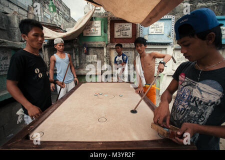 April 7, 2015 - Manila, Manila, Philippinen - Einheimische gesehen verbringen ihre Nachmittag im Slum auf dem Friedhof.. Im Zentrum von Manila Stadtteil von Metro Manila ist ein Friedhof, wo über 10.000 verstorbenen Menschen in Frieden ruht, aber es gibt auch über zwei Hundert von Lebenden am gleichen Ort bleiben Seite an Seite mit den Toten. Viele Familien auf dem Friedhof wegen des Mangels an Fonds und Sie finden den Friedhof der beste Ort, um ein Dach über dem Kopf für freie Stellen. (Bild: © takahiro Yoshida/SOPA über ZUMA Draht) Stockfoto