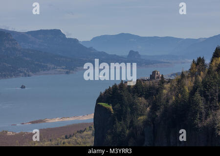 Ein Blick auf den Columbia River Gorge mit dem Vista Haus auf einem Felsvorsprung mit Blick auf den Columbia River und Washington mit einem dunstigen Himmel. Stockfoto