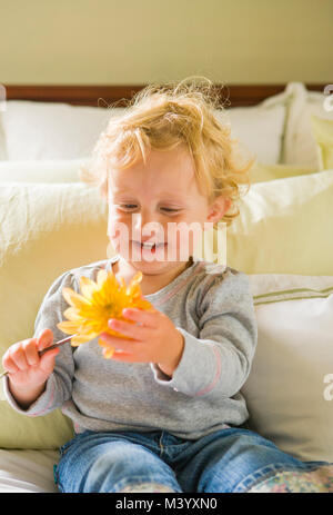 Ein Mädchen, das Kleinkind in einer Schnittblume hält sie in den Händen. Stockfoto