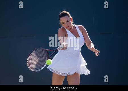 Eine junge Frau tennis player Hits eine Vorhand auf einem Tennisplatz in Beverly Hills, Kalifornien. Foto von Francis Specker Stockfoto