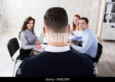 Ansicht der Rückseite ein Geschäftsmann eine Präsentation halten zu seinem Mitarbeiter im Büro Stockfoto