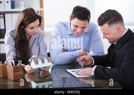 Paar Planung neues Haus Projekt mit Architekt im Büro Stockfoto