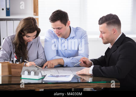 Paar Planung neues Haus Projekt mit Architekt im Büro Stockfoto