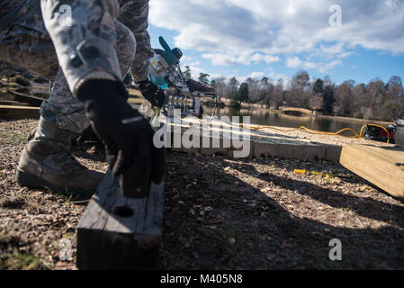 Us Air Force 1 Lt Alvin Yip, 20. Bauingenieur Squadron stellvertretender Offizier der Anforderungen und der Optimierung, Maßnahmen ein Stück Holz vor der Gedenkstätte See bei Shaw Air Force Base, S.C., Feb 5, 2018. Freiwillige gereinigt der Park und die Brücke und im Pavillon am See aufgebaut, und arbeiten daran, den überlauf Brücke zu bauen. (U.S. Air Force Foto von älteren Flieger Destinee Sweeney) Stockfoto