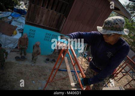 Royal Thai Navy Chief Petty Officer 1 Pairate Ruksawong, Construction Engineer Regiment, aus der Provinz Rayong, Thailand, gibt Anweisungen zur US-Marine Seeleute aus dem Naval Mobile Konstruktion Bataillon 4, Feb 7, 2018 während der Übung Cobra Gold 2018. Soldaten und Matrosen von der Royal Thai Navy, Singapur Armee und der US-Marine, arbeiteten zusammen, eine Mehrzweck-class Zimmer für das Wat Sombum Naram Schule in der Provinz Rayong, Thailand zu errichten. Cobra Gold 2018 unterhält konzentrieren sich auf humanitäre Civic action, Engagement für die Gemeinschaft und medizinischen Tätigkeiten während der Übung durchgeführt, um die nee Unterstützung Stockfoto