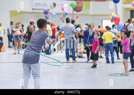 HUMACAO, Puerto Rico, 6. Januar 2018 - Junge Tänze mit dem Hula Hoop Gabe, die ihm während der Drei König Feier am Humacao Arenas Kolosseum gegeben wurde. Administración de Servicios de Salud Mental y Contra la Adicción (ASSMCA), das in Zusammenarbeit mit dem Außenministerium, FEMA, und anderen Einrichtungen nahmen an der großen Feier der Heiligen Drei Könige in Aguada, Orocovis, Humacao, Manati, Salinas, und Guaynabo, zum Nutzen der Freude und Geschenke an Kinder und ihre Familien. ASSMCA soll helfen, die emotionale Belastung, die der Hurrikan Maria durch die Erhaltung der traditionellen Pu verringern Stockfoto