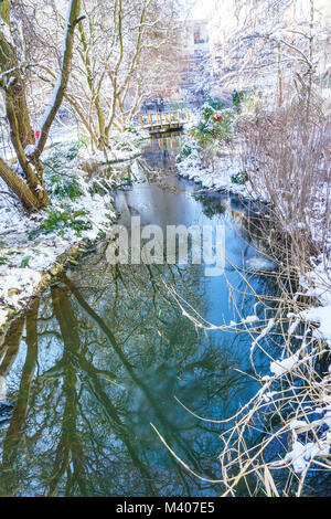 Kleiner Fluss mit mini Pont im Park, Outdoor in Paris, Frankreich, bei Schneefall im Winter. Am Morgen mit dem Sonnenaufgang das Licht genommen. Smart Concept Stockfoto