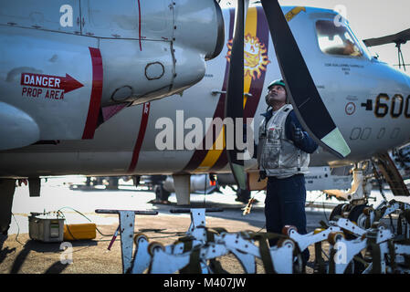 180208-N-VN 584-1317 arabischen Golf (Feb. 8, 2018) die Aviation Machinist Mate 2. Klasse Bhakta Siwa, zugeordnet zu den Sunkings des Trägers Airborne Early Warning Squadron (VAW) 116, die Propeller eines E-2C Hawkeye Kontrollen auf dem Flugdeck der Flugzeugträger USS Theodore Roosevelt (CVN 71). Theodore Roosevelt und ihre Carrier strike Group werden in den USA 5 Flotte Bereich für Maßnahmen zur Erhöhung der Sicherheit im Seeverkehr im Einsatz Verbündeten und Partnern zu beruhigen und der Freiheit der Schiffahrt und des freien Handels in der Region erhalten. (U.S. Marine Foto von Massenkommunikation Besondere Stockfoto