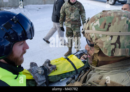 FORT MCCOY, Wis-US Army Reserve Staff Sgt. Javar Manley (rechts), Sanitäter, Task Force Triade, Betrieb Cold Steel II, bespricht der Zustand des Patienten im Notfall Simulator mit der Evakuierung Team während einer medizinischen Evakuierung Probe am Fort McCoy, Wis., Feb 8, 2018. Betrieb Cold Steel ist der US-Armee finden Crew - Serviert Waffen Qualifizierung und Validierung ausüben, um sicherzustellen, dass America's Army Reserve Einheiten und Soldaten ausgebildet sind und bereit, auf kurze bereitstellen - Bekanntmachung als Teil bereit, Kraft X und Bekämpfung - bereit und tödlichen Feuerkraft zur Unterstützung der Armee und unsere gemeinsamen Partner bringen keine Stockfoto