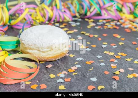 Karneval Donut mit Karneval Dekoration auf einer Schiefertafel Stockfoto