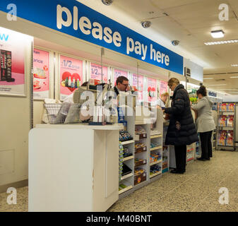 Kunden zahlen für Ihre Einkäufe bei einem großen Stiefel Apotheke in Nordengland Stockfoto