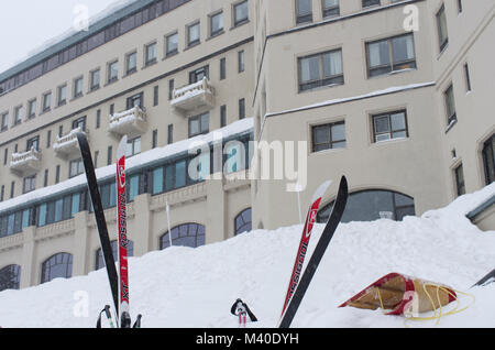 Lake Louise, Alberta, Kanada. Die historische Chateau Lake Louise während eines Januar Schneefall mit Skiern und eine Rodelbahn im Vordergrund. Stockfoto
