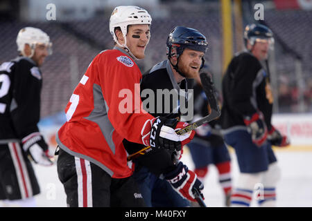 Chicago Blackhawks center Andrew Shaw, Links, und Jeremy Mishler der USA Krieger verwundete Veteranen Hockey Team zu Prüfen jeder andere während eines Media day Spiel für den Winter Classic 2015 in Washington, D.C., 31. Dez., 2014 reagieren. Die beiden Mannschaften spielten pickup team style Hockey für etwa 15 Minuten auf dem Eis im Freien an den Angehörigen Stadion. (DoD Nachrichten Foto durch EJ Hersom) 141231 - D-DB 155-005 von DoD News Fotos Stockfoto