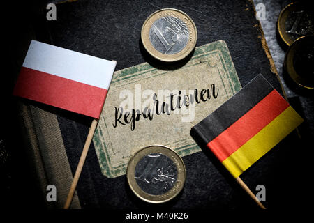 Flaggen von Deutschland und Polen und buchen Sie mit der Aufschrift Reparationen, Fahnen von Deutschland und Polen und Buch mit der Aufschrift Reparationen Stockfoto