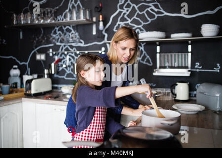 Ein kleines Mädchen mit ihrer Mutter kochen zu Hause. Stockfoto