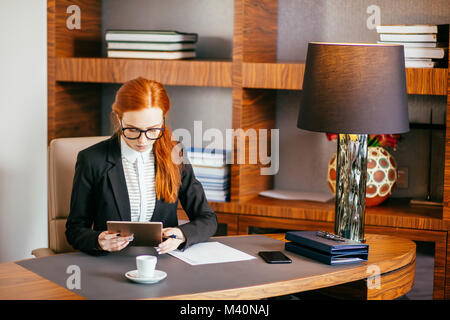 Geschäftsfrau Brille mit digitalen Tablette im Büro Stockfoto