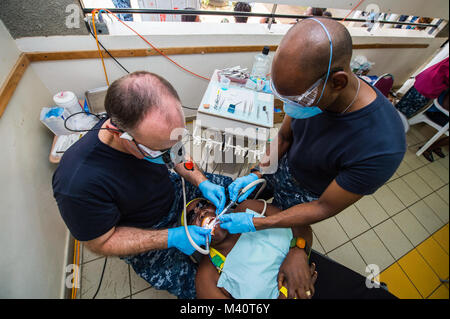 150803-N-NK 134-069 PORTSMOUTH, Dominica (Aug. 3, 2015) - Lt.Cmdr. James Ward, ein Eingeborener von Las Vegas, Nev und Zahnarzt zu U.S. Naval Hospital Neapel, Italien zugewiesen, Links, und Hospital Corpsman 3. Klasse Ralph Hawker, ein Eingeborener von Houston, Texas, zu Naval Hospital Beaufort, S.C. zugeordnet wird, führen Sie einen zahnmedizinischen Verfahren auf einem Patienten an einer medizinischen Website an der Roosevelt Douglas Grundschule zur Unterstützung der Fortsetzung Versprechen 2015 gegründet. Weiterhin Versprechen ist ein US Southern Command - gefördert und U.S. Naval Forces Southern Command/USA Flotte - durchgeführt, um die Bereitstellung zu zivil-militärischen Oper Verhalten Stockfoto